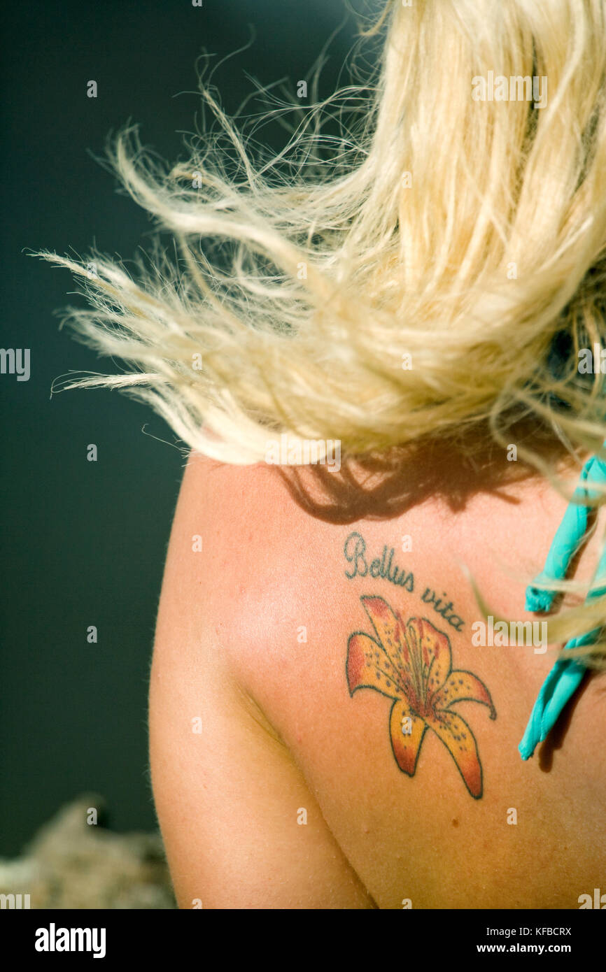 USA, Hawaii, Oahu, rear view of woman with a flower tattoo on her back Stock Photo