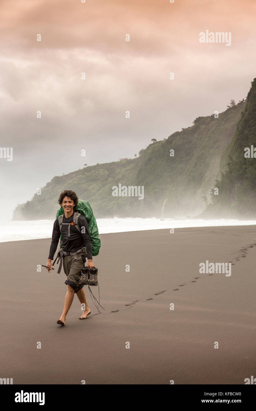 USA, Hawaii, The Big Island, backpacker walks on the beach along the
