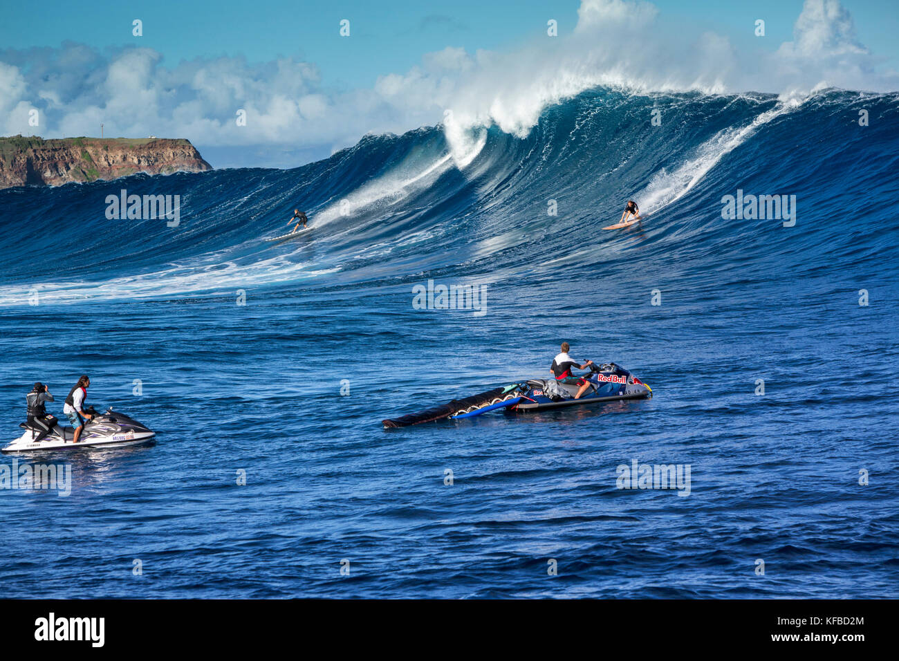 USA HAWAII Maui Jaws big wave surfers taking off on a wave at