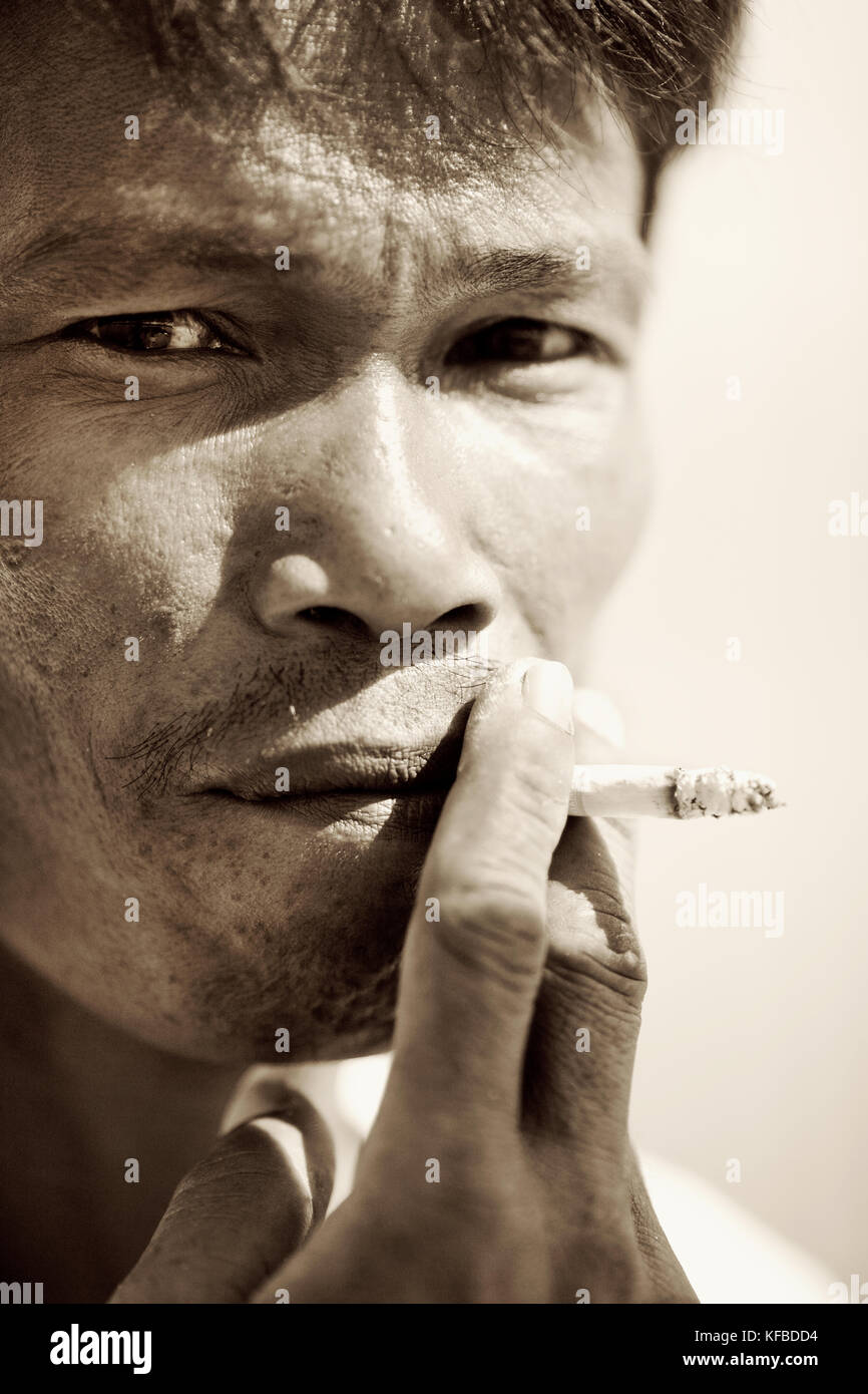 INDONESIA, Mentawai Islands, Kandui Resort, close-up of mid adult man smoking cigarette (B&W) Stock Photo