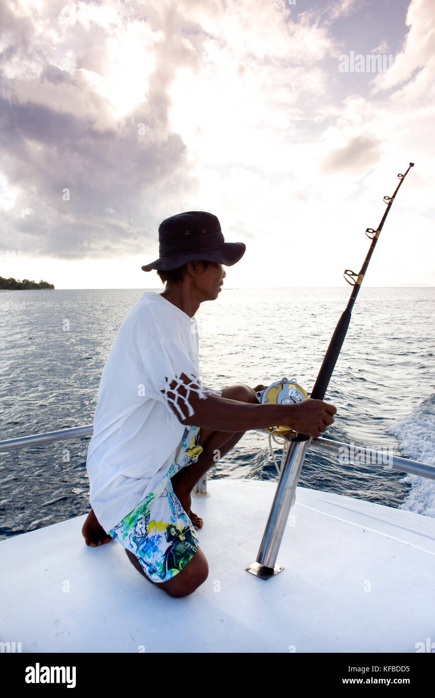 INDONESIA, Mentawai Islands, mid adult man fishing from a boat Stock Photo