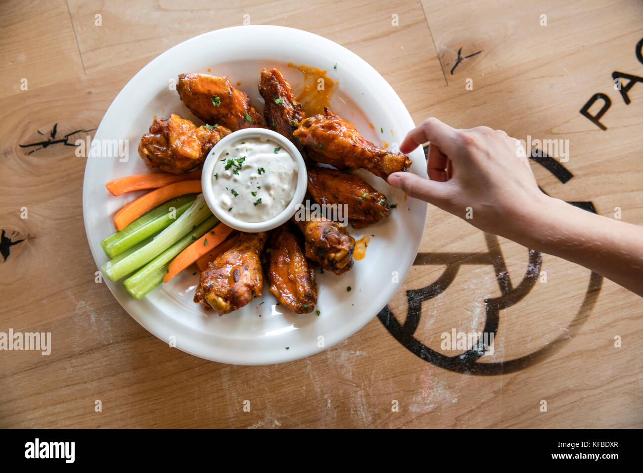 USA, Oregon, Bend, Pacific Pizza and Brew, hot wings grab Stock Photo