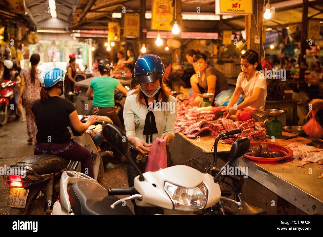VIETNAM, Hanoi, a young woman buys meat from a butcher in the Chau Long