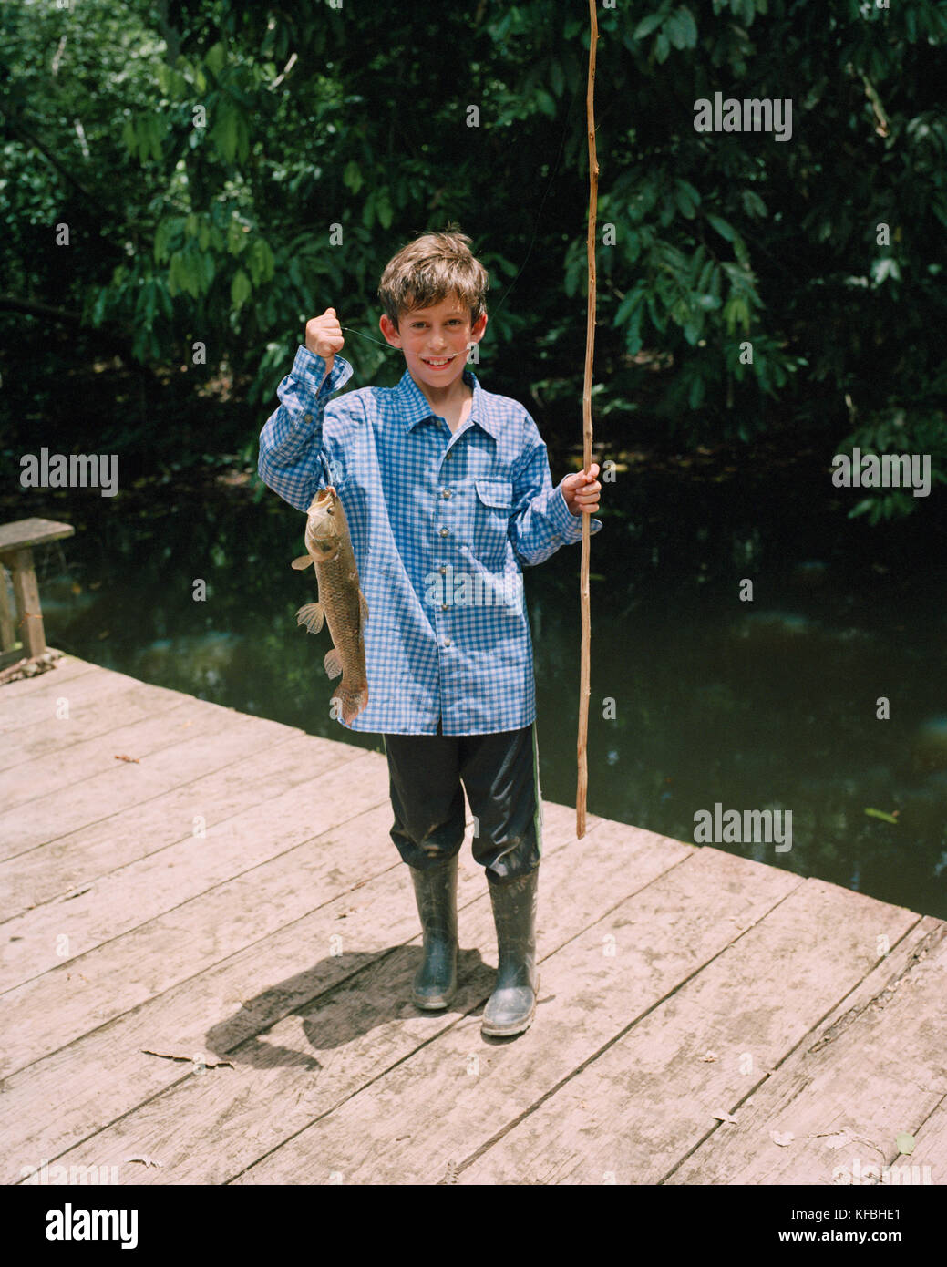 PERU, Amazon Rainforest, South America, Latin America, portrait of a Asa with a fish he just caught from the Tambopata River. Stock Photo