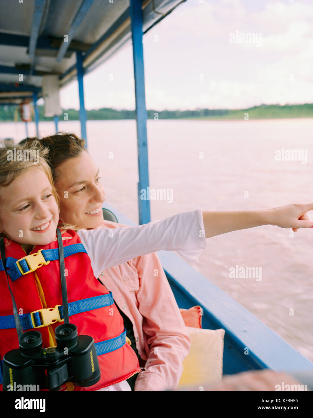 PERU, Amazon Rainforest, South America, Latin America, smiling mother and daughter travelling in boat along the Tambopata River. Stock Photo