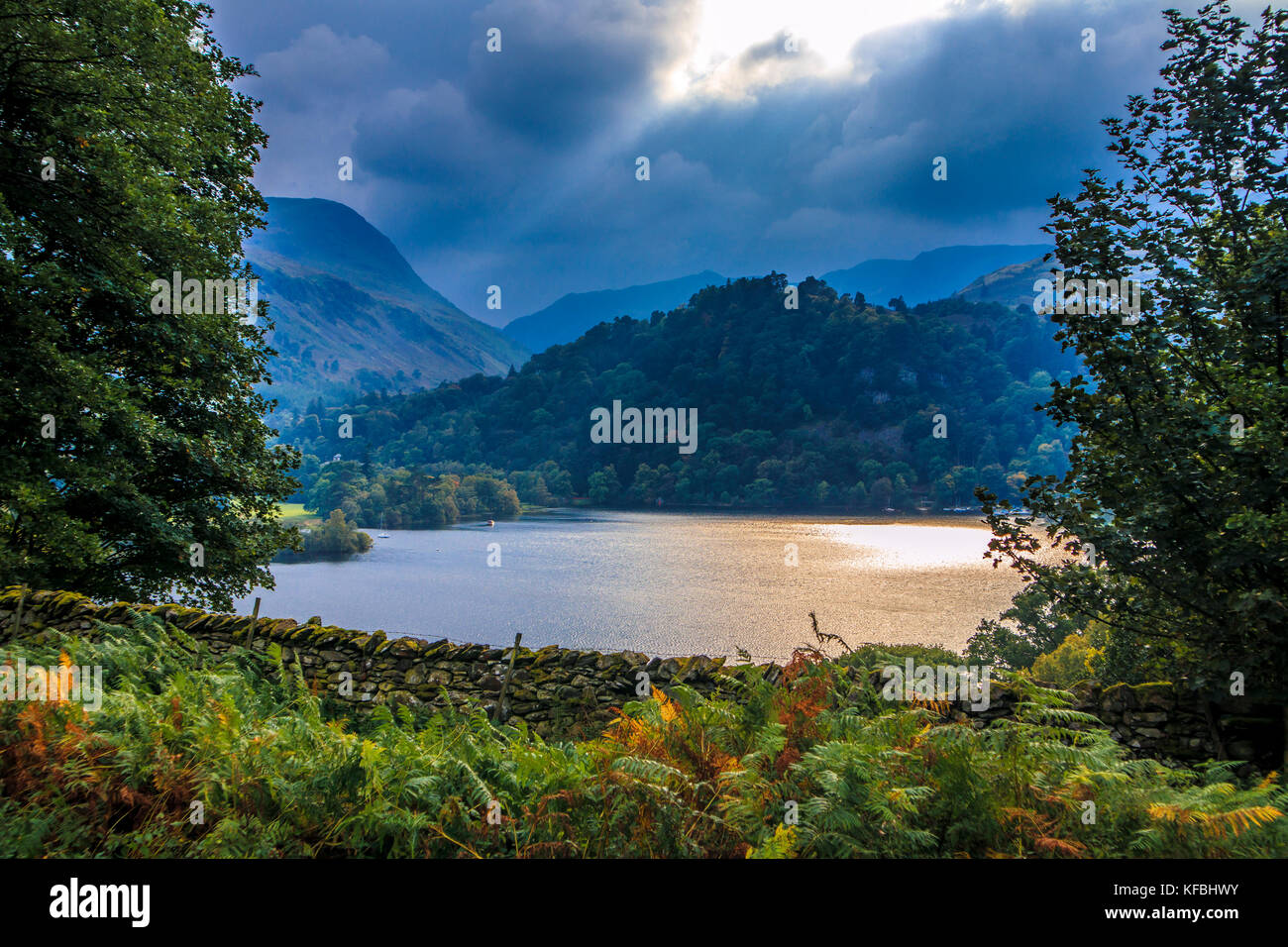 View of a threatening stormy sky and a ray of sunshine on Ullswater in the English Lake District Stock Photo