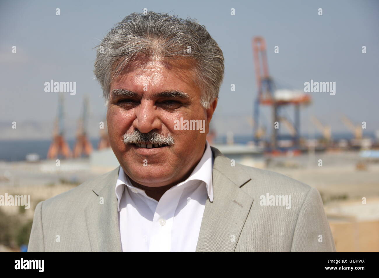 Dostain Jamaldini, Director of the Gwadar Port Development Authority standing in his office's balcony in Gwadar, Baluchsitan, in the southernmost tip of Pakistan, 04 October 2017. From the balcony there is a clear view to what is supposed to one day become a mega port. Heavy-duty cranes for loading and unloading of container ships can be seen in the background. According to Jamaldini Gwadar is to become the largest shipping port of South Asia by 2022 and one of the largest in the world in 30 years' time. Gwadar is a hub of the planned so-called 'China-Pakistan Economic Corridor', or CPEC for s Stock Photo