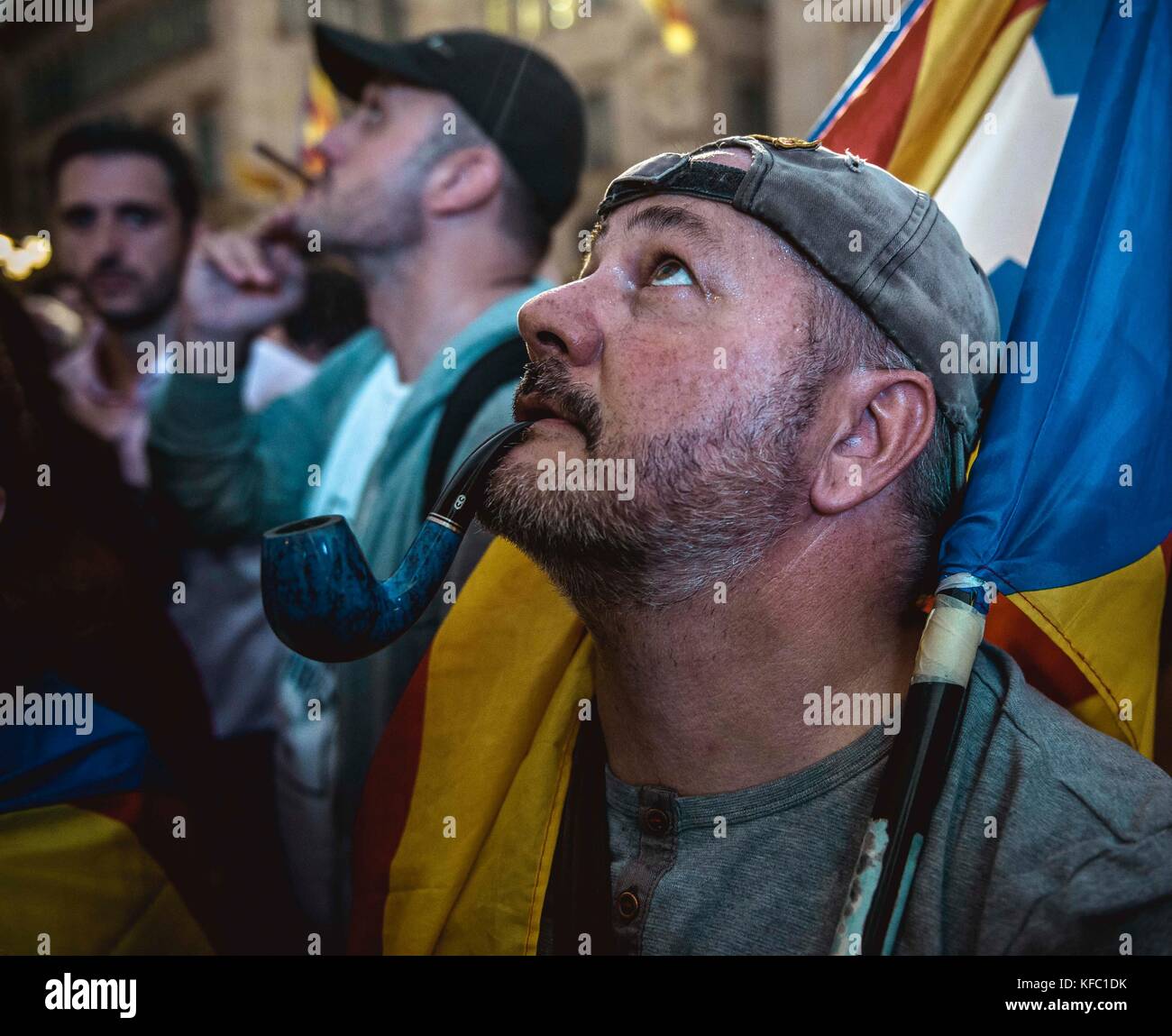 Barcelona, Spain. 27 October, 2017:  A Catalan separatist smokes his pipe as he celebrates the parliaments independence vote in front of the 'Generalitat' Credit: Matthias Oesterle/Alamy Live News Stock Photo