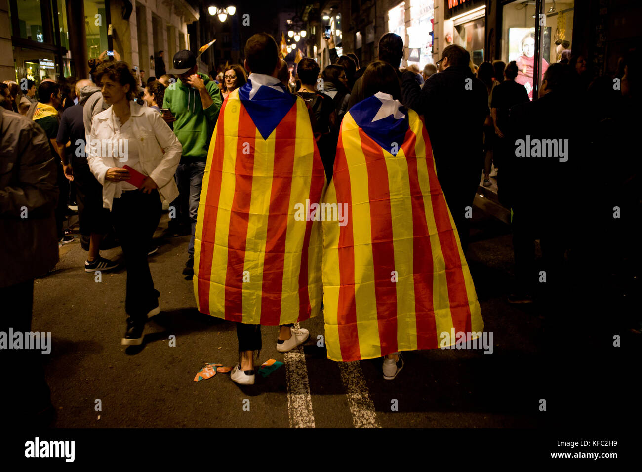 Barcelona, Spain. 27th Oct, 2017. October 27, 2017. A couple wrapped with estelada or pro-independence flags is seen walking in the Gothic Quarter of Barcelona.  Catalonia's parliament voted to declare independence from Spain and proclaim a republic, just as Madrid is poised to impose direct rule on the region to stop it in its tracks. Credit:  Jordi Boixareu/Alamy Live News Stock Photo