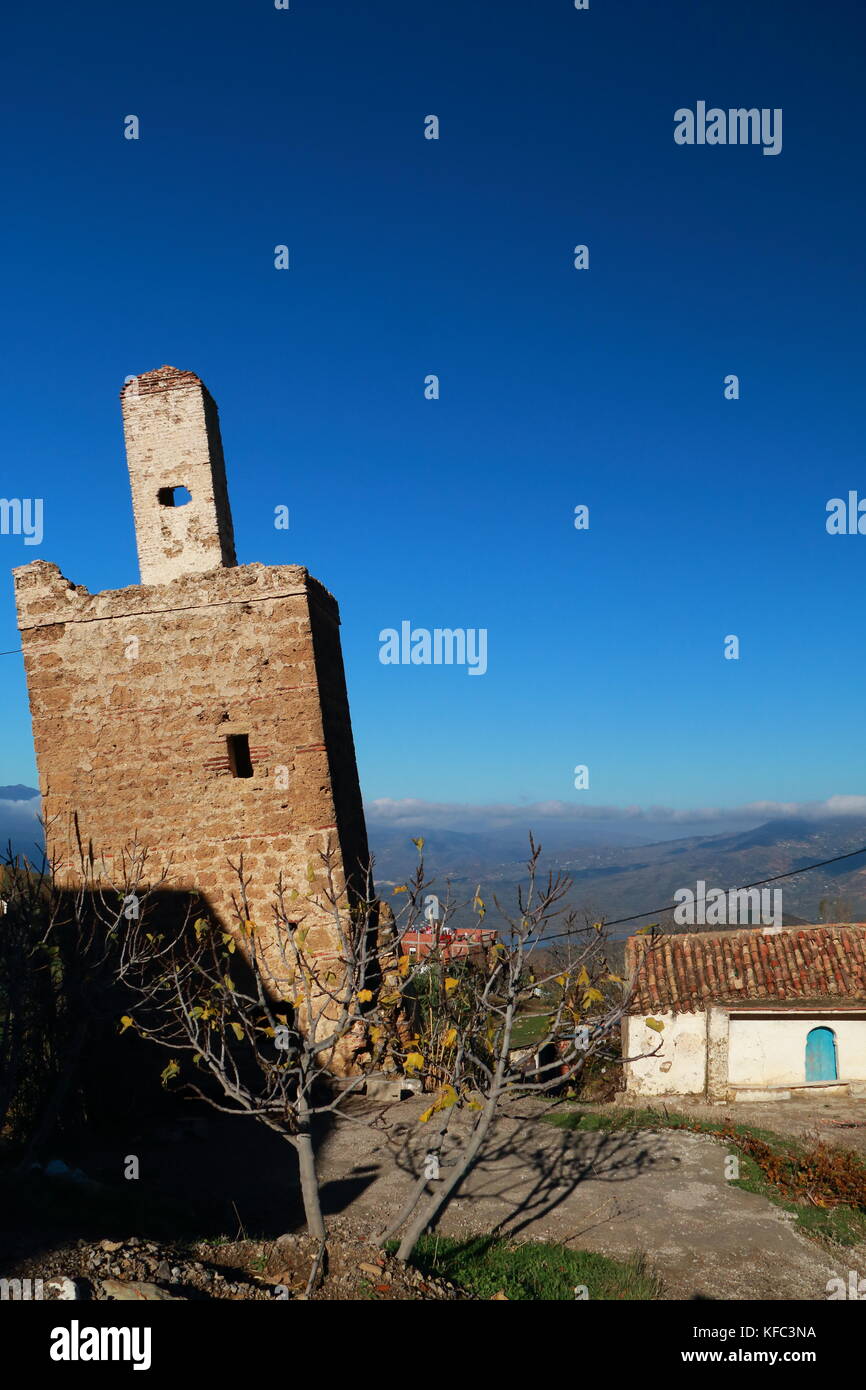 Inclined minaret of ancient mosque next to a house. Vertical image. Stock Photo