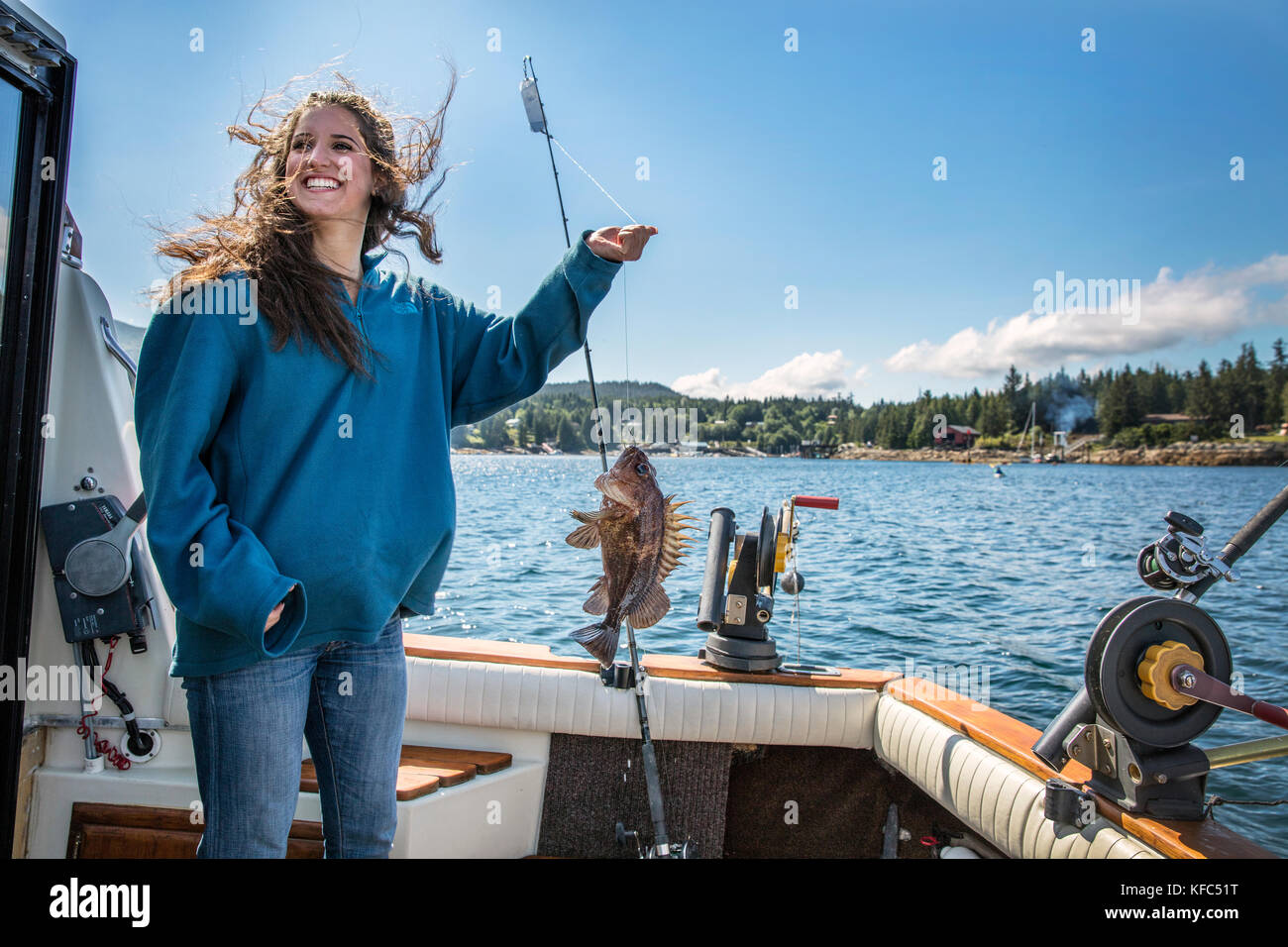 USA, Alaska, Ketchikan, a female fisherman shows off her catch while fishing the Behm Canal near Clarence Straight, Knudsen Cove along the Tongass Nar Stock Photo