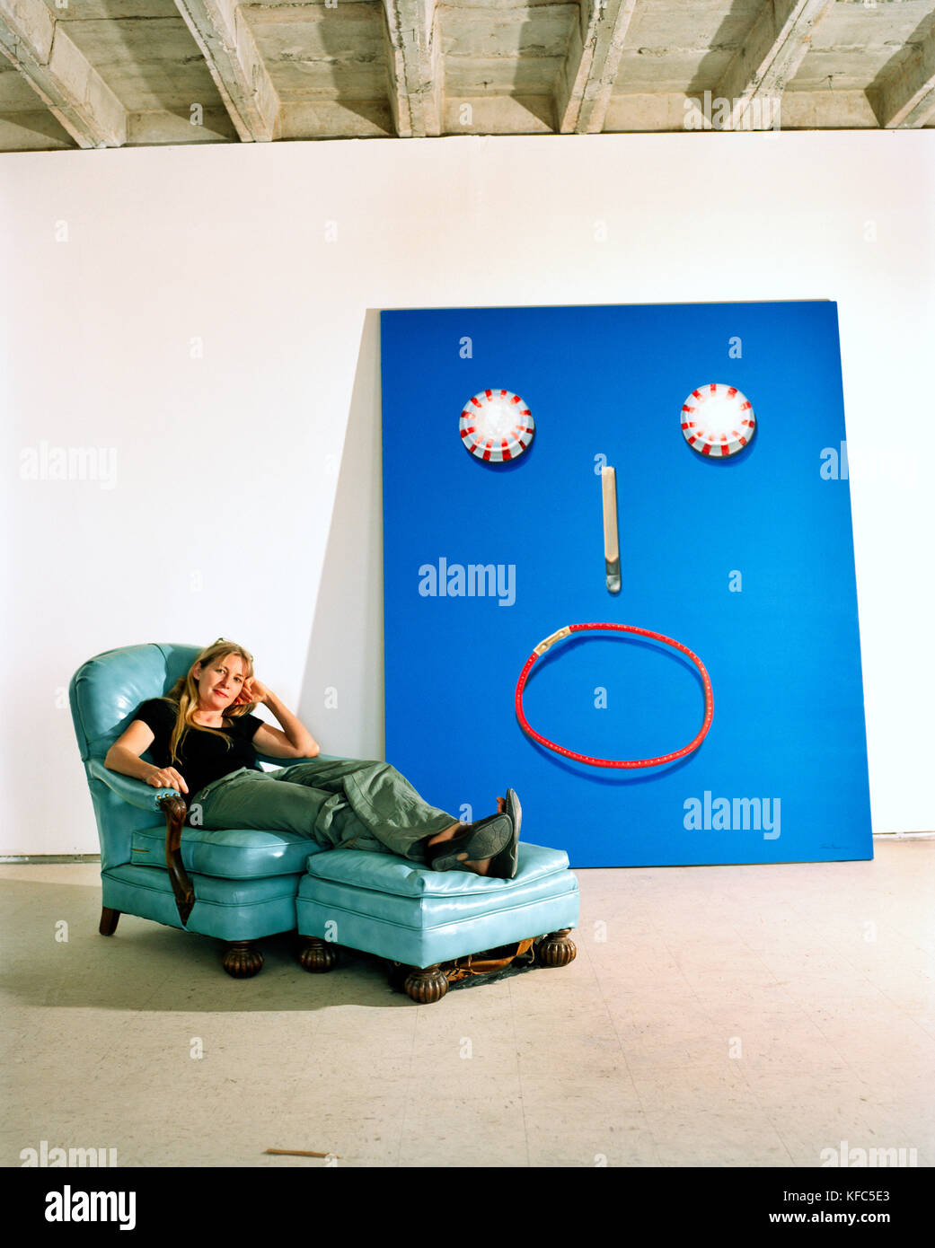 USA, Arizona, female artist relaxes in armchair next to her painting starry eyes, Winslow Stock Photo