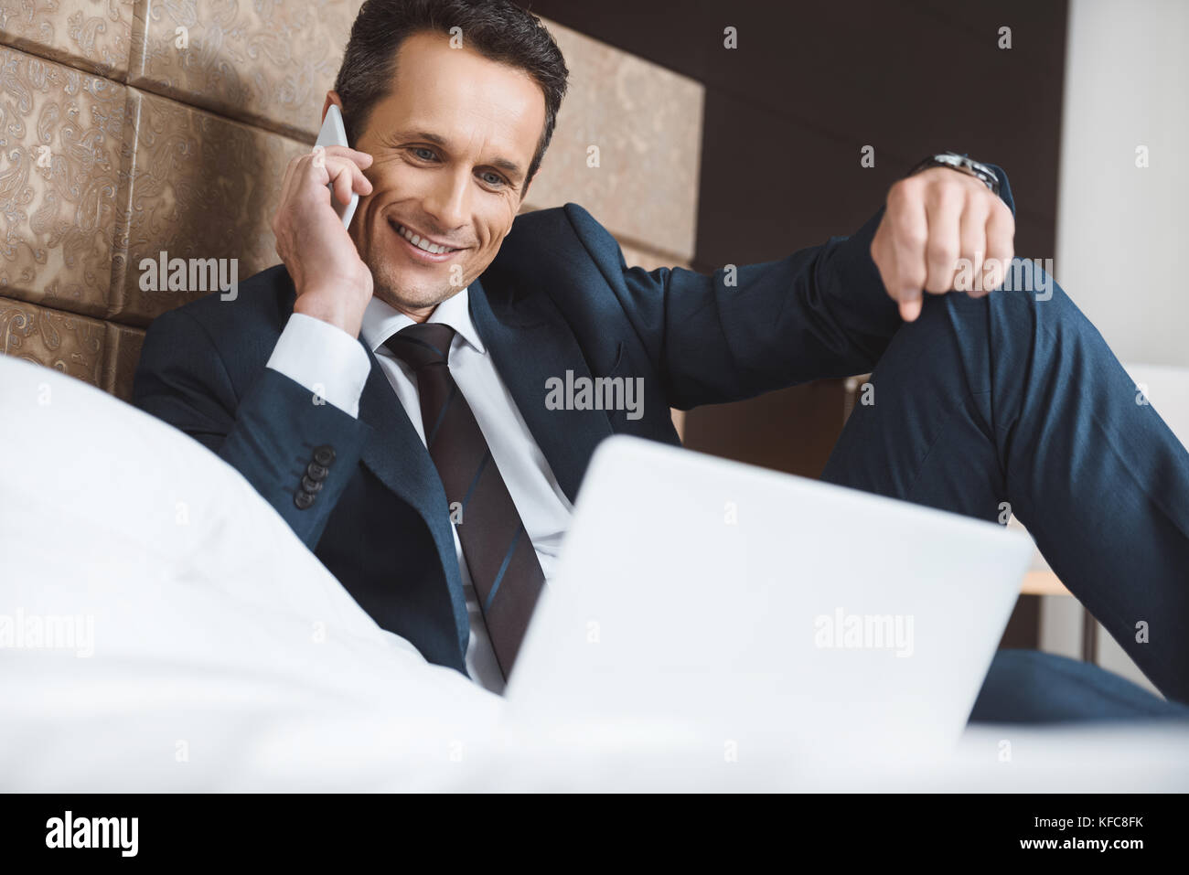 businessman on bed talking on phone Stock Photo - Alamy