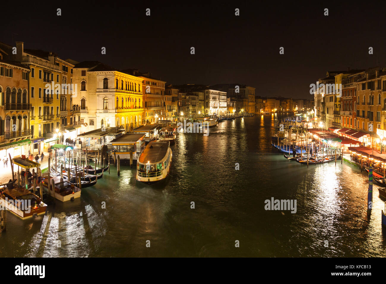 ITALY, Venice. View of the Grand Canal, homes, shops,  and restaurants from the Rialto Bridge at night. Stock Photo