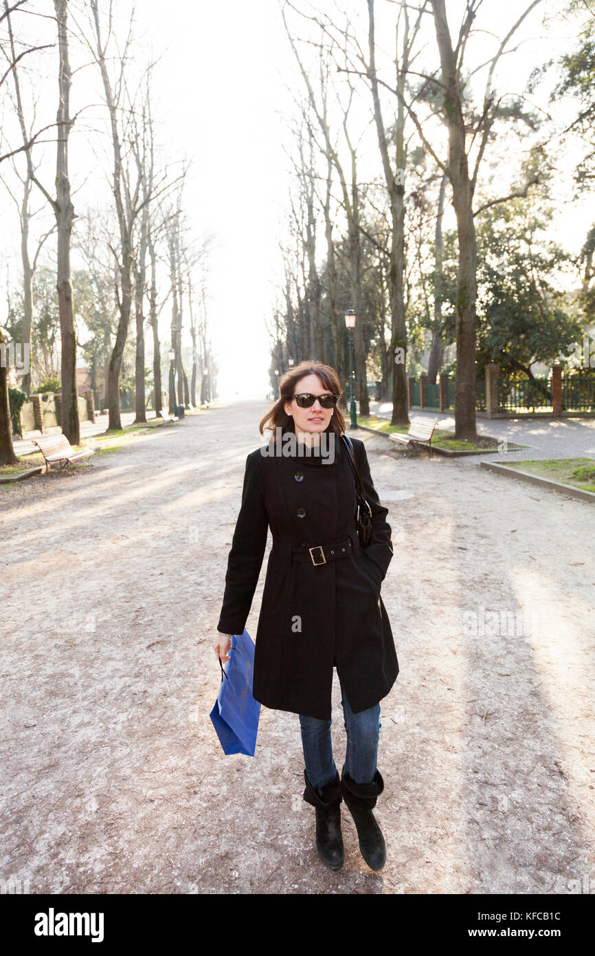 ITALY, Venice. Artist Mia Kaplan walking along the tree lined Viale Giuseppe Garibaldi in the Castello district of Venice. Castello is the largest of  Stock Photo