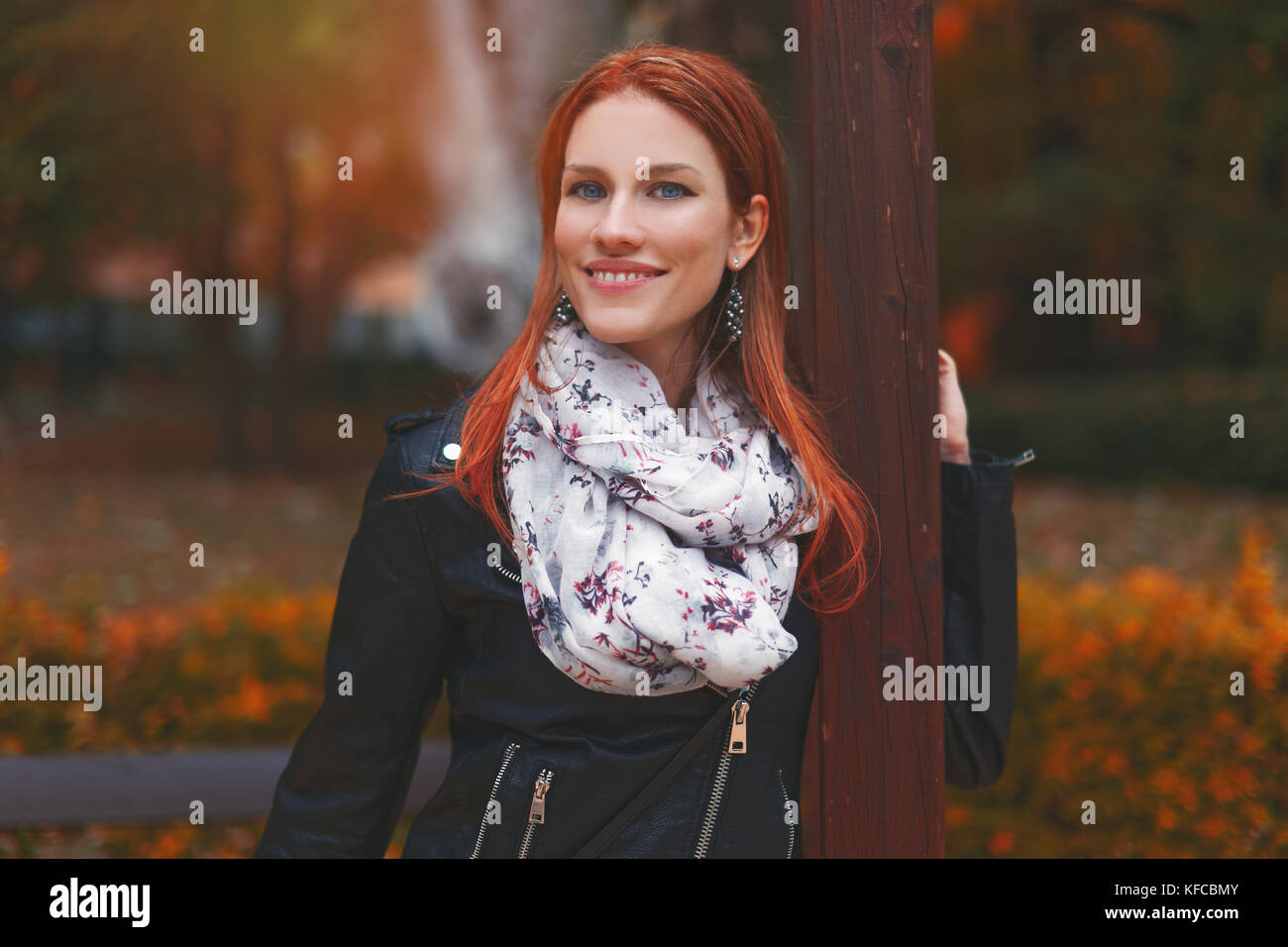 Redhead beautiful young woman posing in park at autumn Stock Photo - Alamy