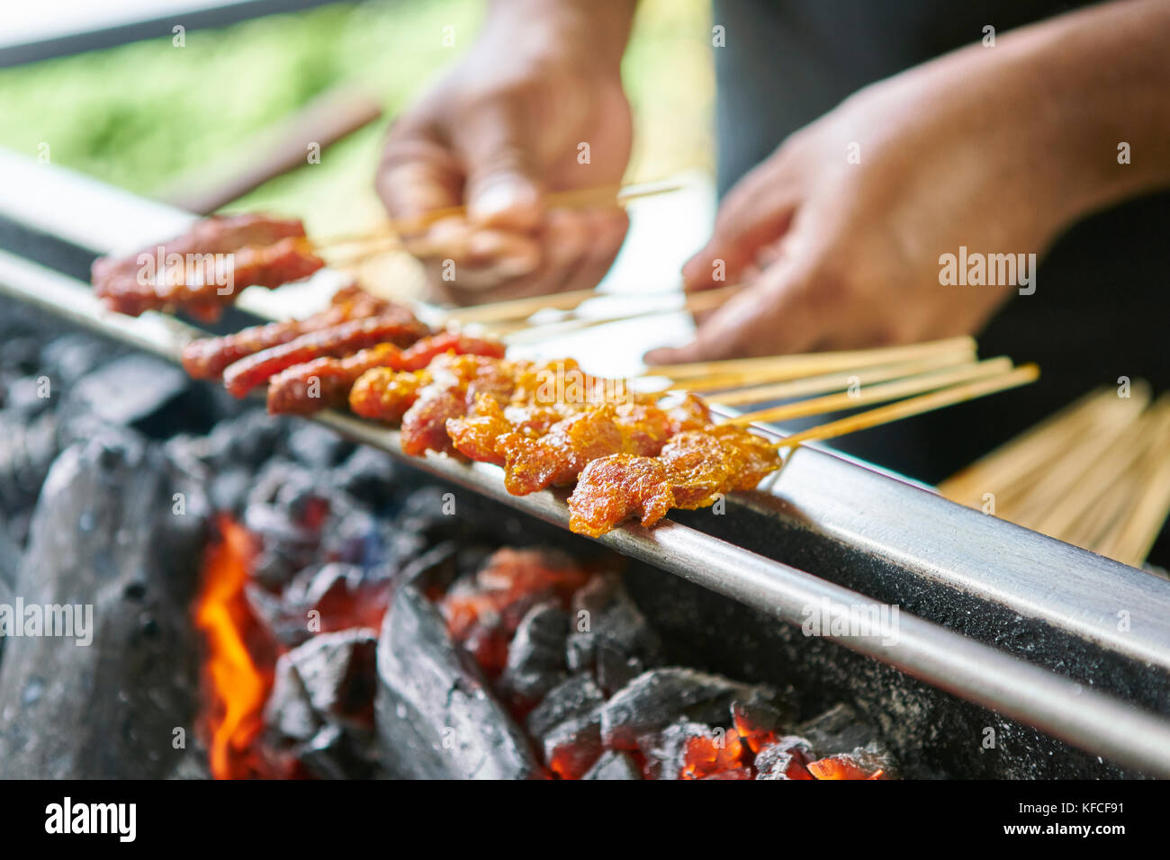 A man cooks satay over hot coals in Singapore - Satay by the Bay Stock Photo