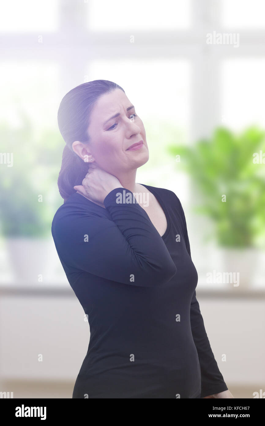 Middle aged woman with chronic pain syndrome fibromyalgia suffering from acute neckache Stock Photo