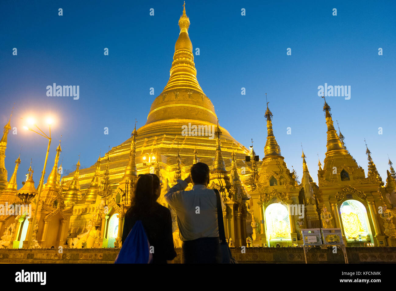 Myanmar (formerly Burma). Yangon. (Rangoon). Couple front of the Stupa of Shwedagon Pagoda. Buddhist holy place is the first religious center of Burma Stock Photo