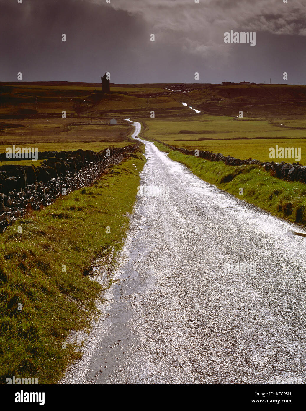 Ireland. Doolin. Road in landscape with distant Doonagore Castle. Stock Photo