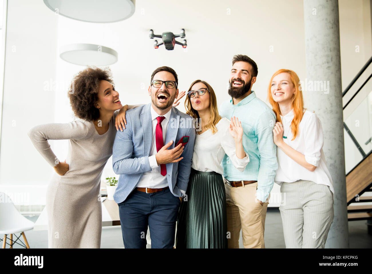 Young business people letting the drone camera to fly over the office and having fun Stock Photo Alamy