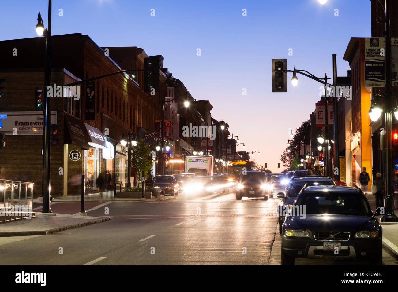 Traffic and silhouetted historical buildings along Princess Street at dusk in downtown Kingston, Ontario, Canada. Stock Photo