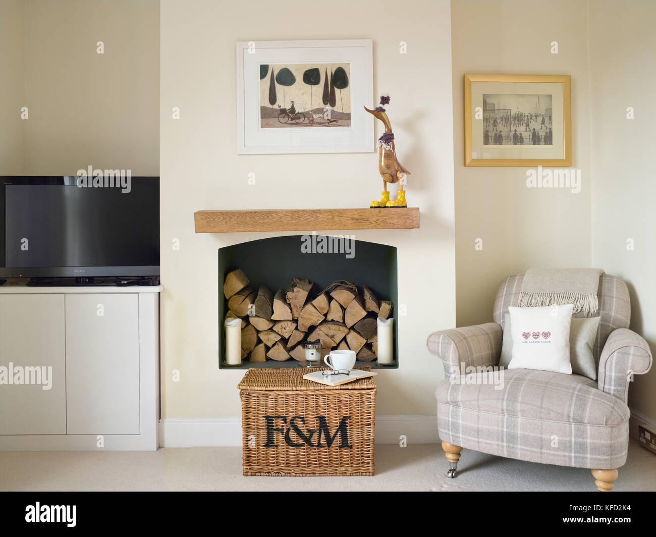 A cosy living room, showing a chair, fireplace & television in a UK home Stock Photo