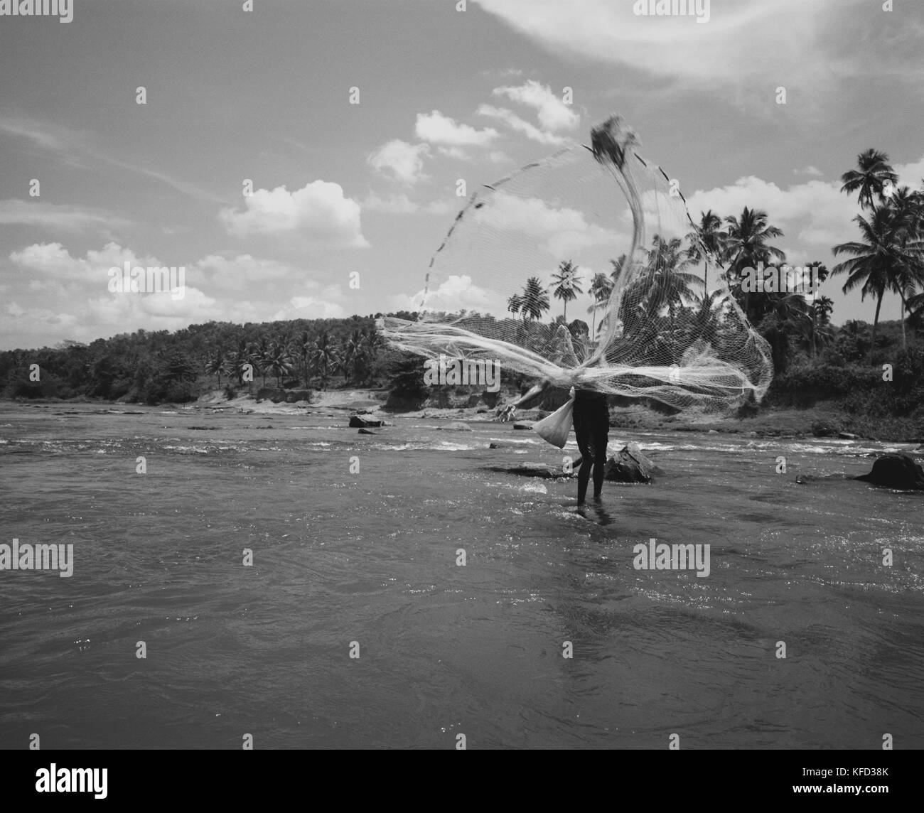 SRI LANKA, Asia, fisherman throwing fishing net in Maha Oya river (B&W