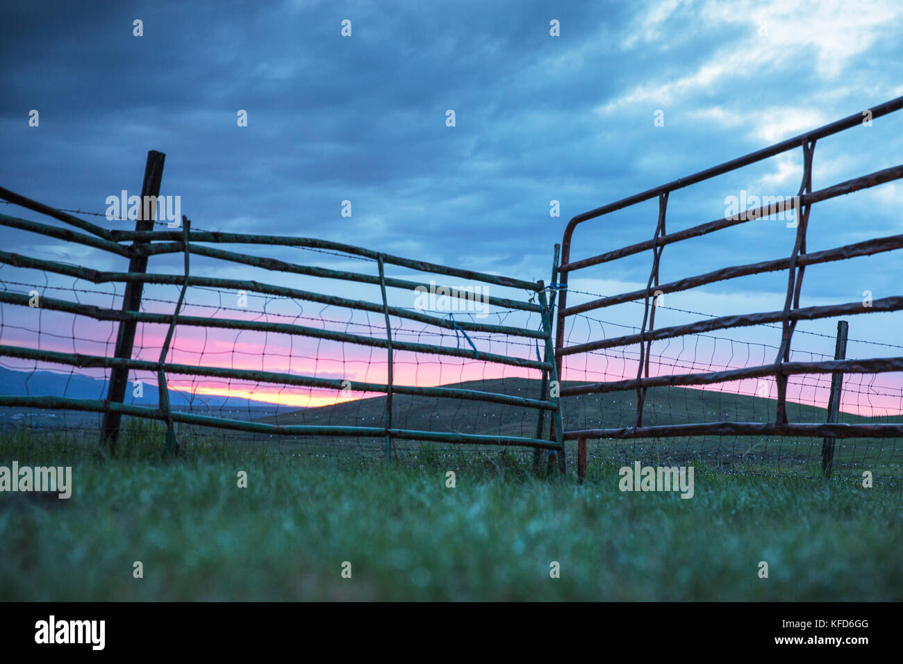 USA, Oregon, Enterprise, looking through a fence at Sunset towards the Eagle Cap Wilderness and the Wallowa Mountains, Wallowa-Whitman National Forest Stock Photo