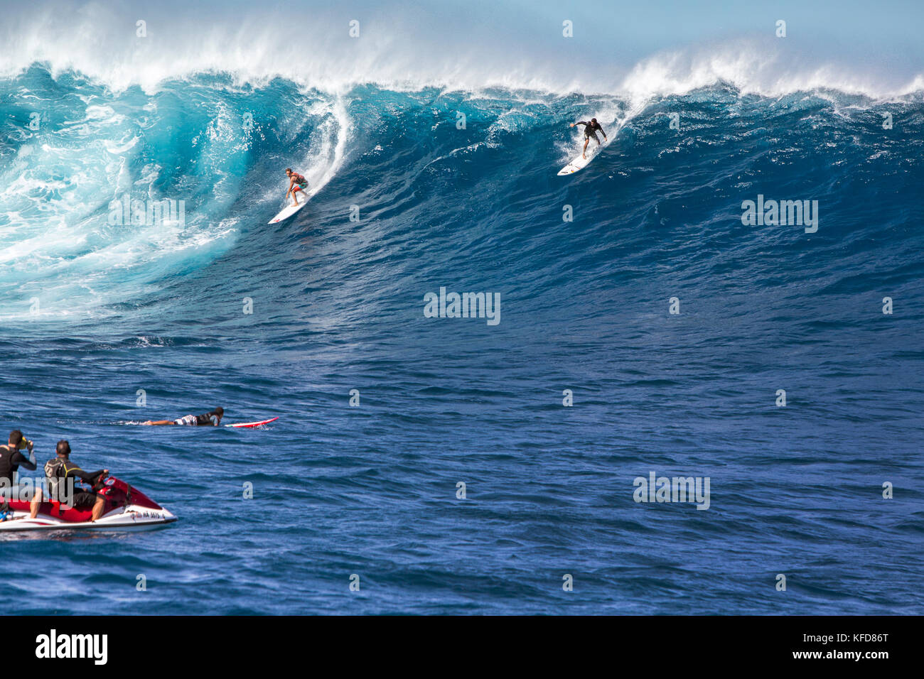 USA, HAWAII, Maui, Jaws, big wave surfers taking off on a wave at Peahi