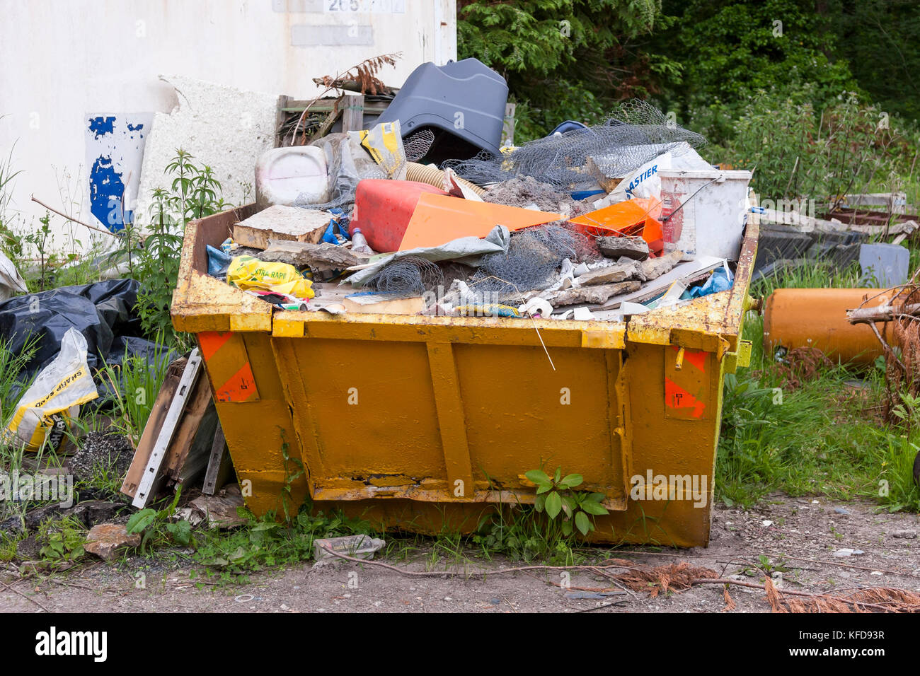 builders waste disposal skip overflowing with rubbish Stock Photo