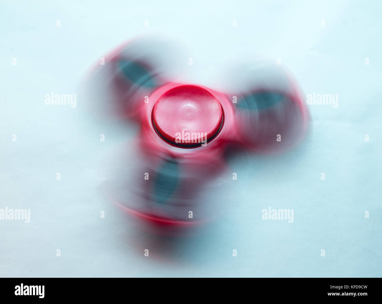 Red Fidget Spinner in motion on white background Stock Photo
