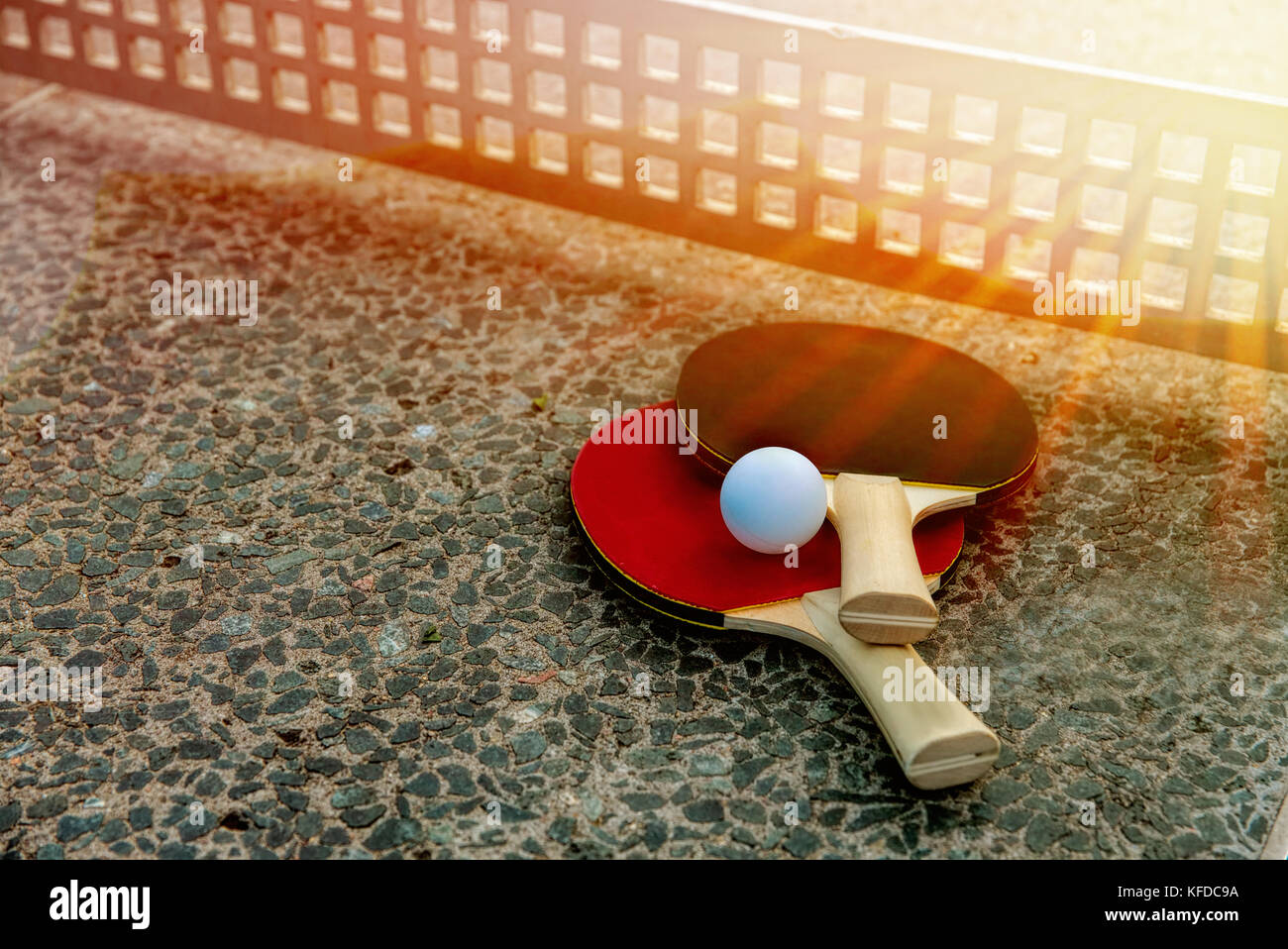 close up of ping-pong ball with tennis rackets on stone tennis table in  sunny lights, Equipment for outdoors table tennis. Outdoor sport concept.  Spor Stock Photo - Alamy