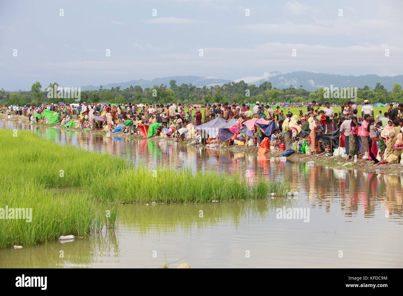 Newly arrived Myanmar’s minority Rohingya Muslims, who crossed over from Myanmar into Bangladesh, rest on embankments after spending a night in the op Stock Photo