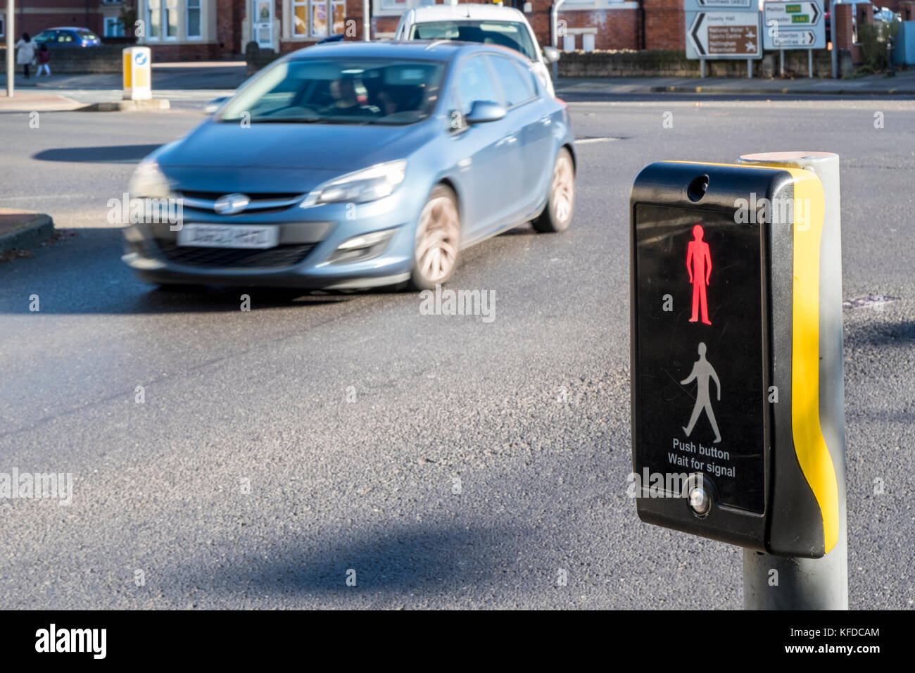 Stop signal at a puffin pedestrian crossing control. Puffin crossing showing red man while traffic passing, Nottinghamshire, England, UK Stock Photo