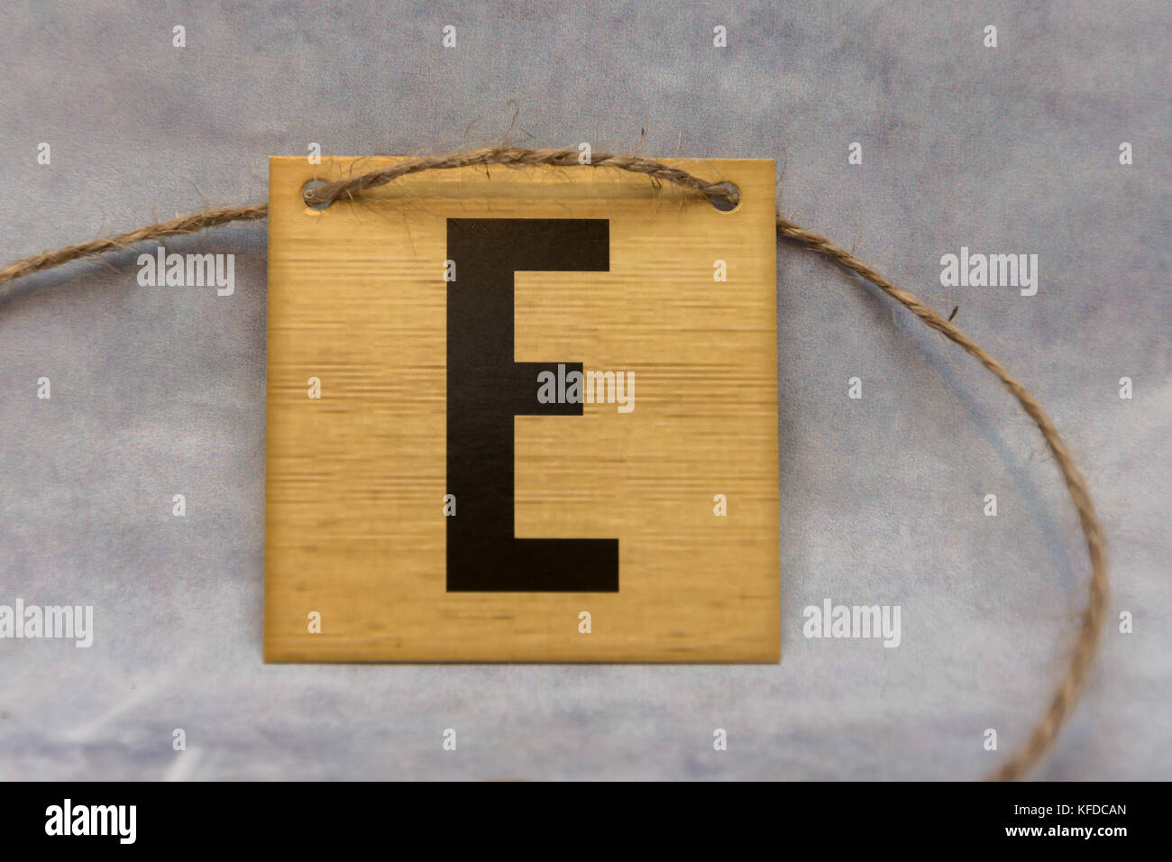 isolated tile letter of the alphabet on a patterned grey background ...