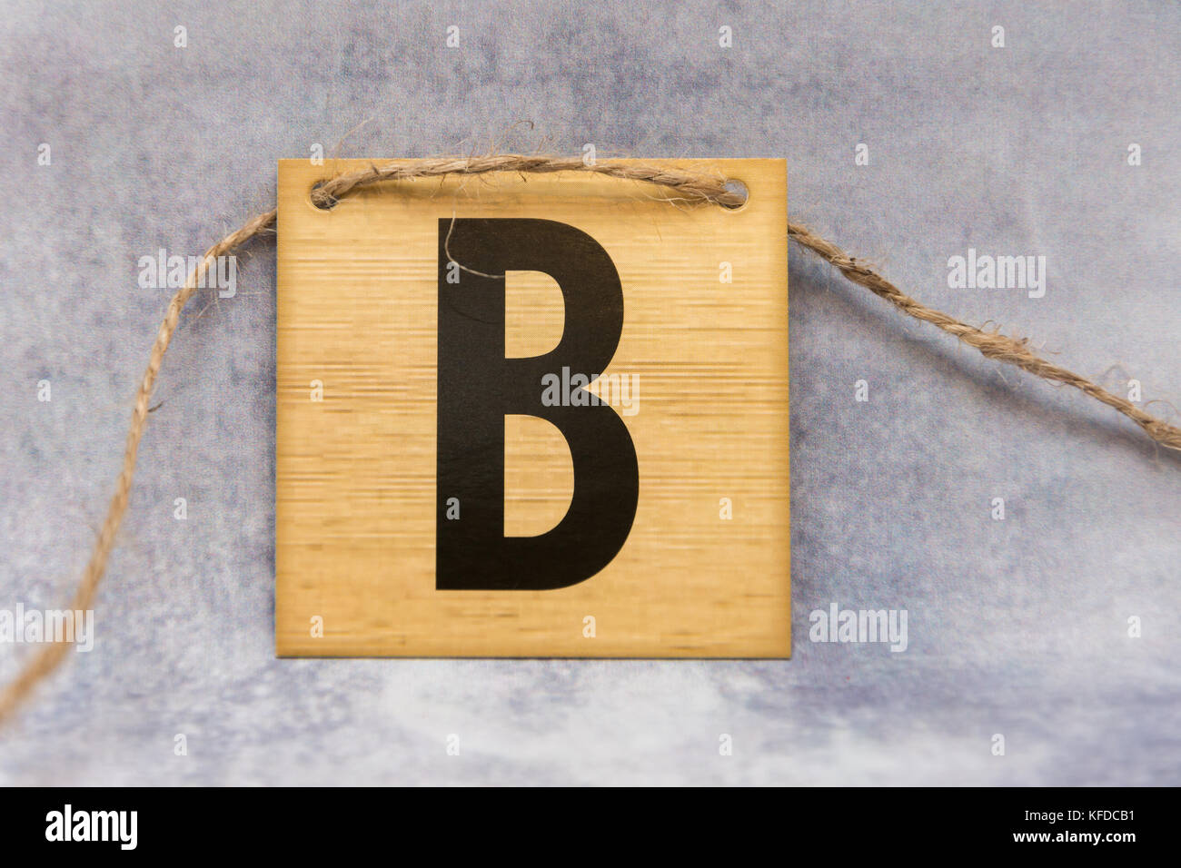 isolated tile letter of the alphabet on a patterned grey background ...