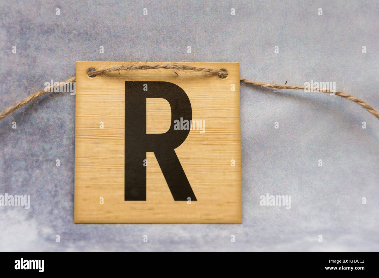 isolated tile letter of the alphabet on a patterned grey background ...