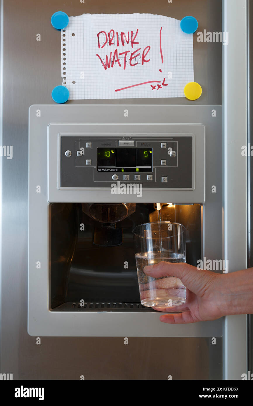 https://c8.alamy.com/comp/KFDD6X/a-hand-holding-a-glass-under-the-water-dispenser-of-an-american-style-KFDD6X.jpg