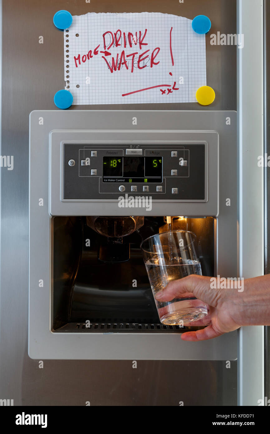 https://c8.alamy.com/comp/KFDD71/a-hand-holding-a-glass-under-the-water-dispenser-of-an-american-style-KFDD71.jpg