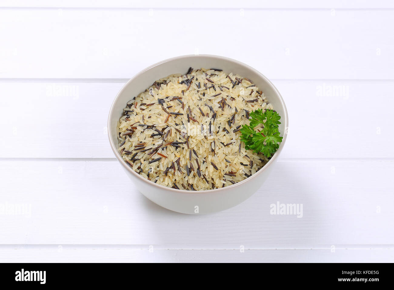 bowl of wild rice on white wooden background Stock Photo