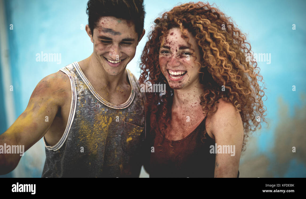 Two people covered in paint splatter and smiling. Stock Photo