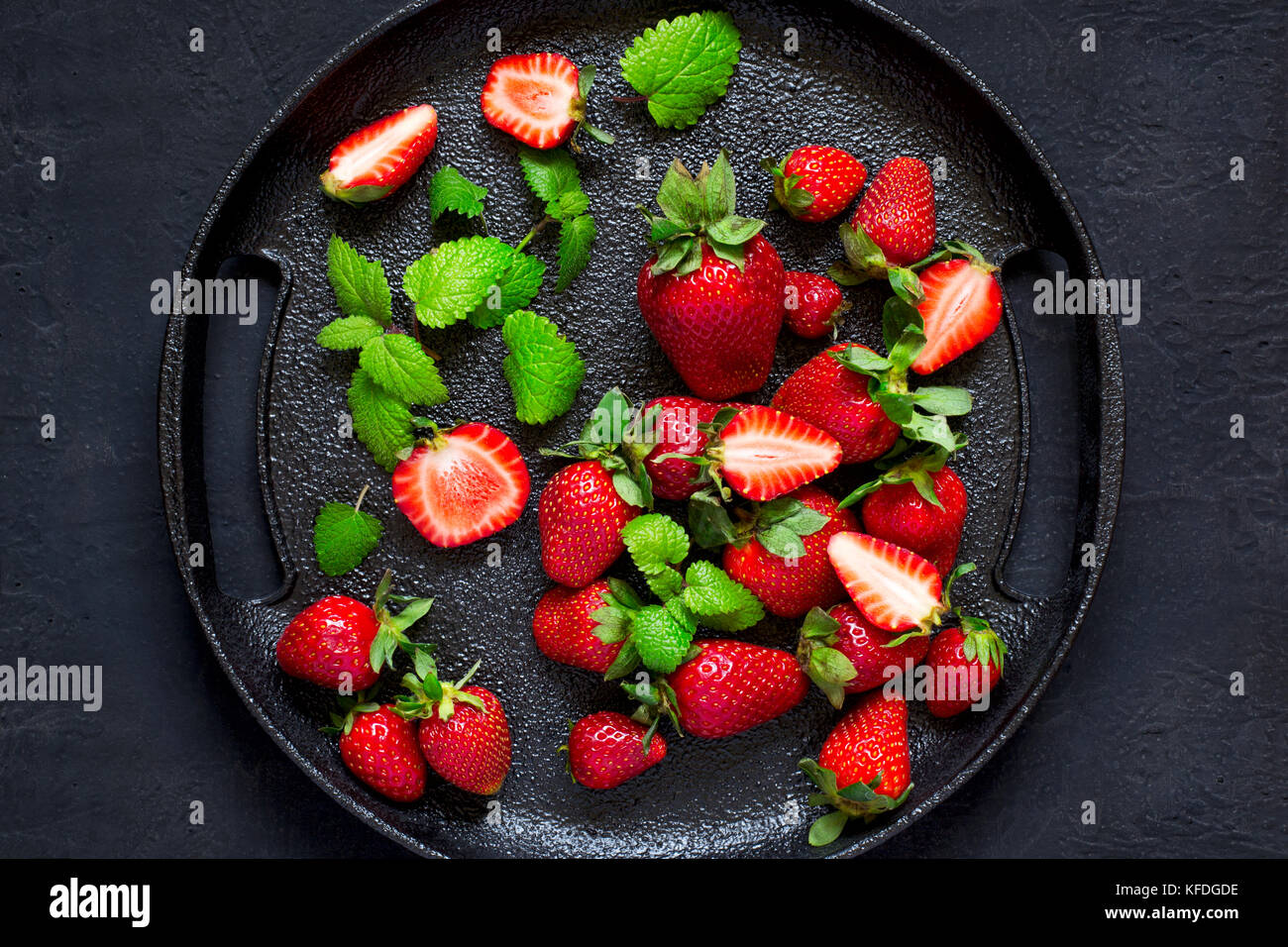 Juicy ripe strawberries on a black cast-iron dish. Top view Stock Photo ...