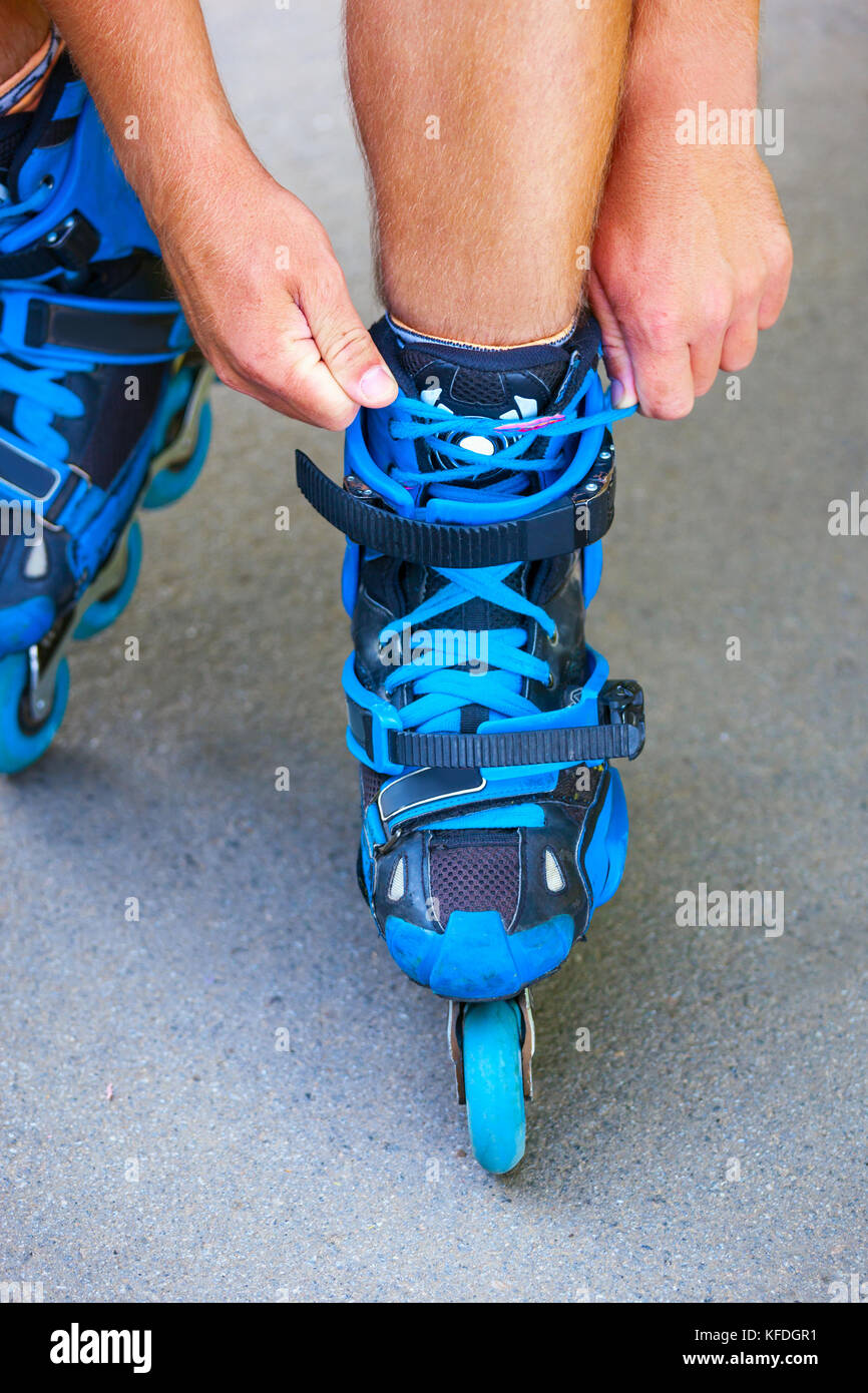 Close up photo of roller tying laces on inline roller skates Stock