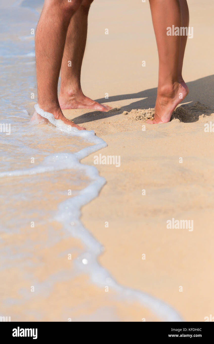 Legs of a kissing couple in love on a sea beach Stock Photo