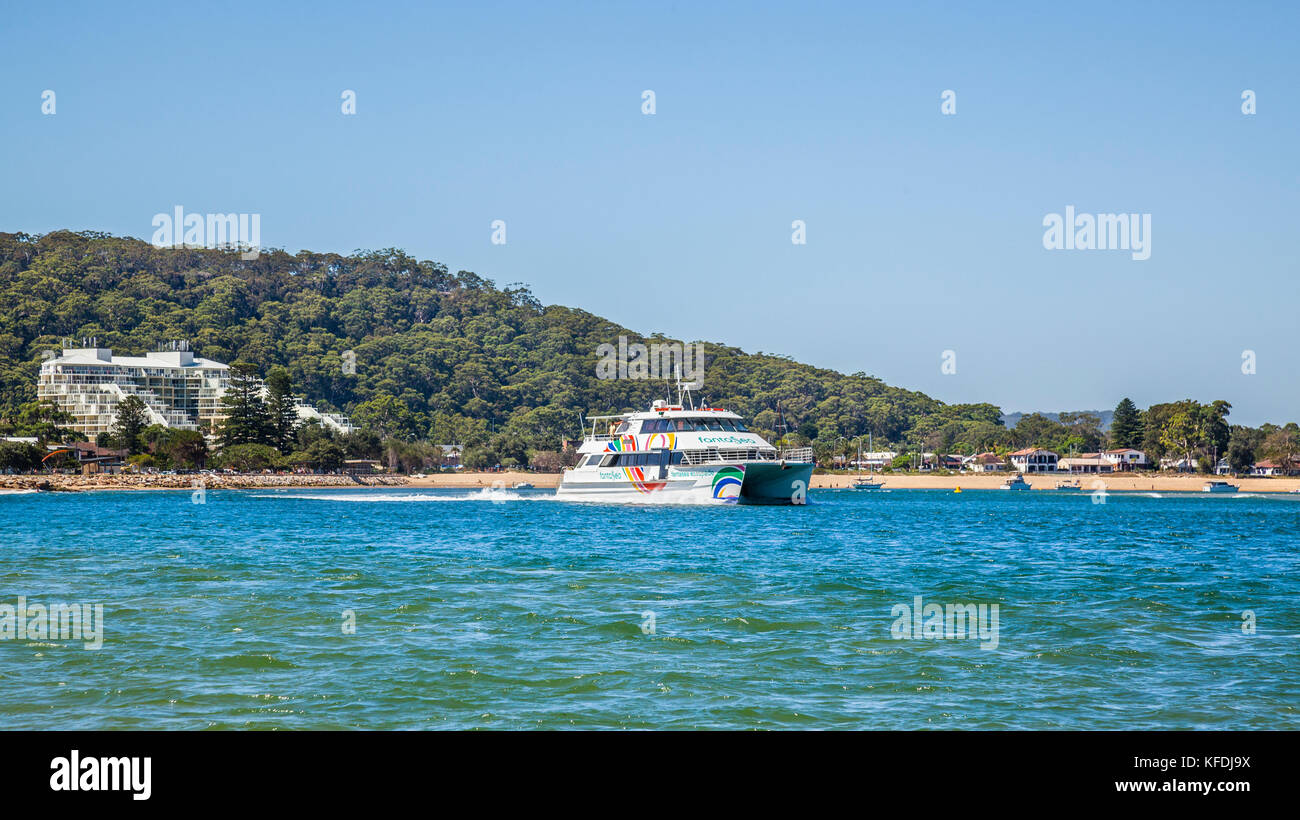 Australia, New South Wales, Central Coast, Ettalong Beach, the catamaran ferry to Palm Beach against the backdrop of the Mantra Resort and Blackwall M Stock Photo