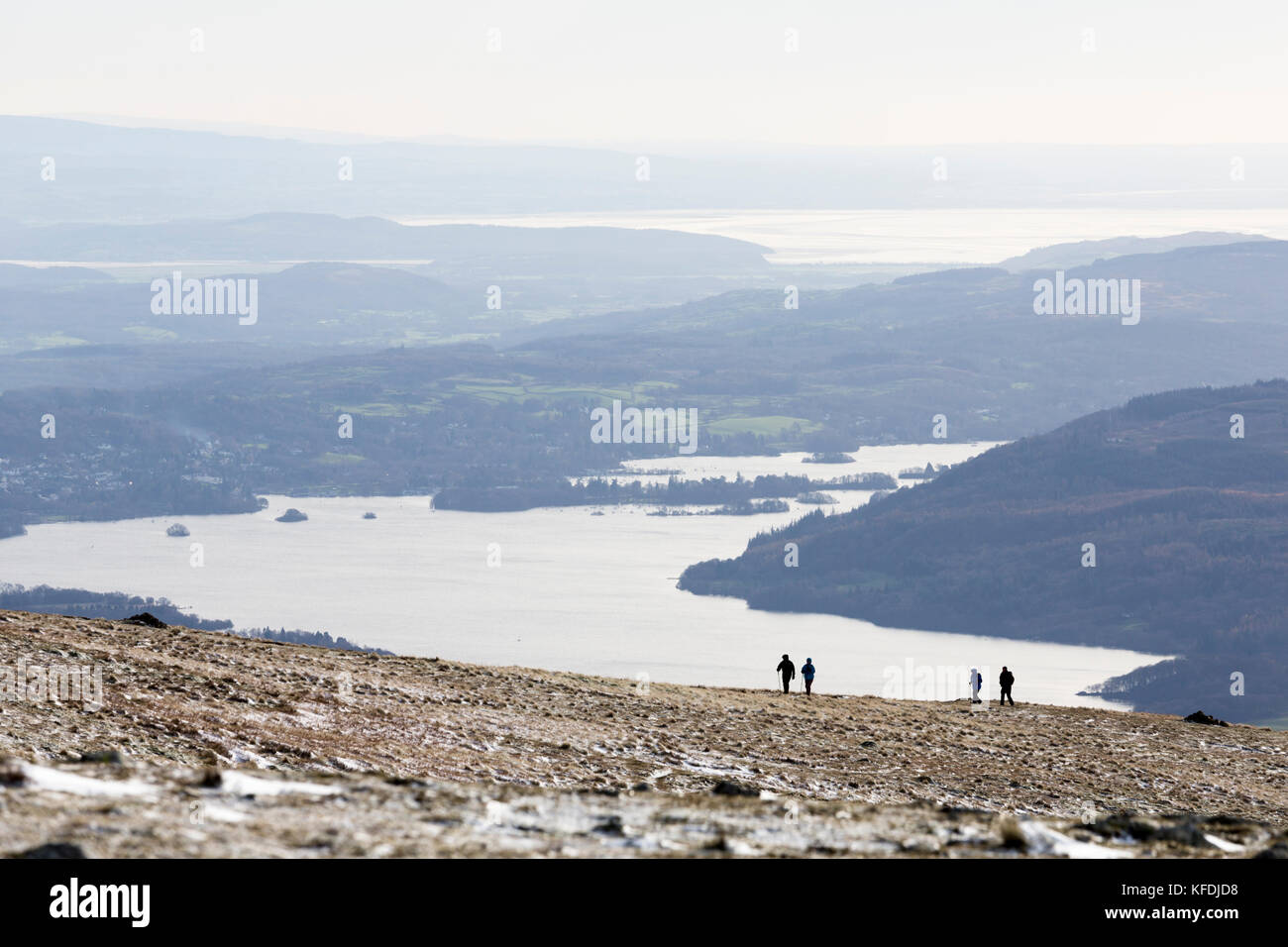 Winter walkers on the Fairfield Horseshoe with Lake Windermere in the background. Stock Photo