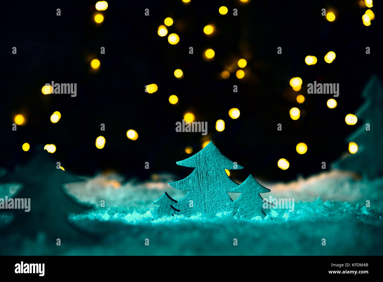 Wooden Christmas Tree In Green Spotlight On White Snow And Snowflakes