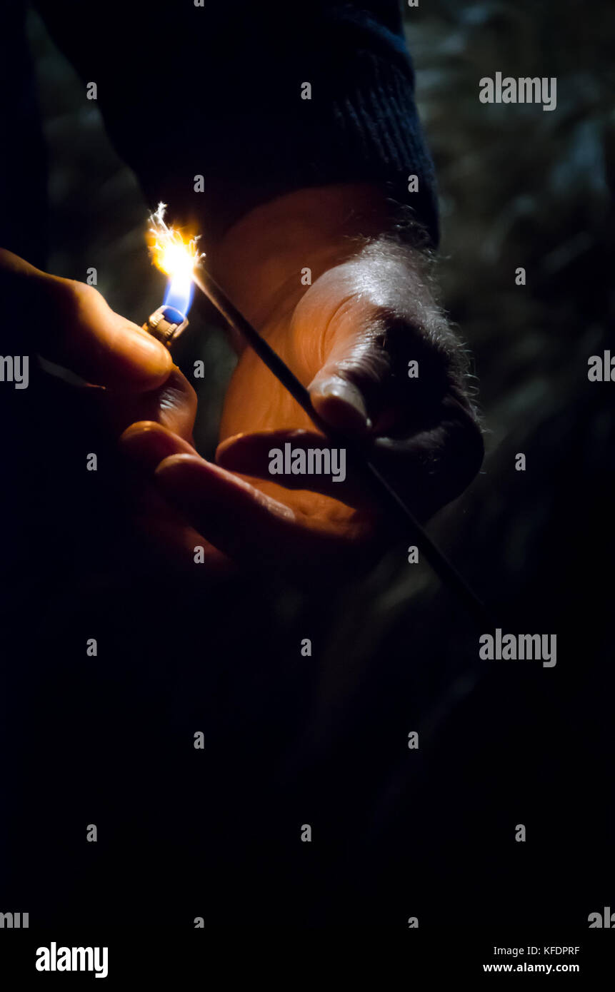 Male hands lighting a sparkler with a cigarette lighter Stock Photo Alamy