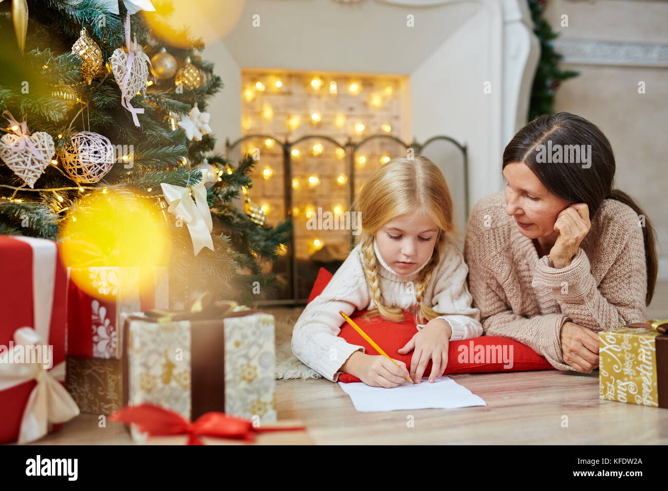 Cute little girl writing letter to Santa on xmas night with her ...